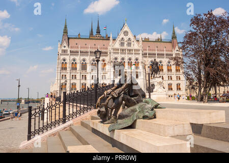 Budapest, Hungary - June 4, 2017: Sitting sculptural portrait of hungarian poet Attila Jozsef placed on the stairs near Hungarian parliament and Danub Stock Photo