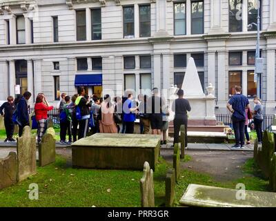 Tour group of young people at the grave of Alexander Hamilton in the Trinity churchyard, New York, NY, USA. Stock Photo