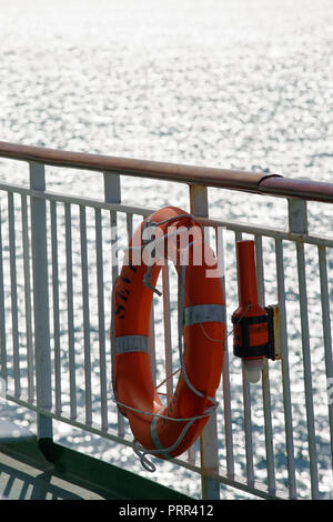 A life ring or lifebuoy attached to railings of a ship, ready to be ...