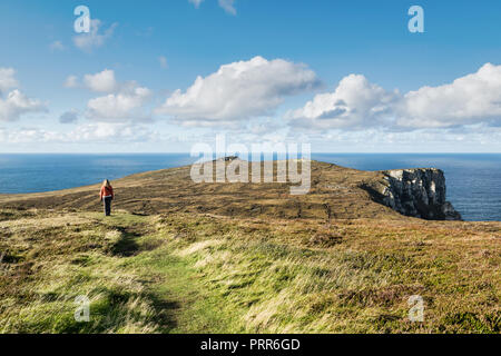 This is a women near the sea cliffs of Horn Head Ireland looking up towards the ocean horizon. Stock Photo