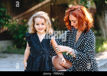 A young mother combs her little daughter's hair Stock Photo