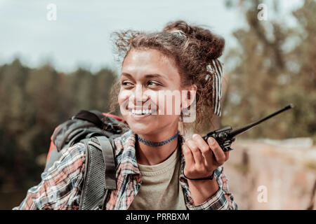 Beaming female hiker feeling cheerful while meeting her friend in mountains Stock Photo