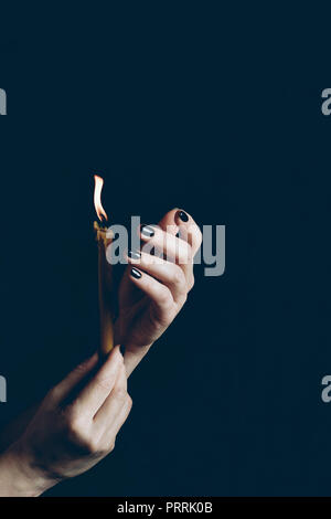cropped view of gothic woman holding flaming candle isolated on black Stock Photo