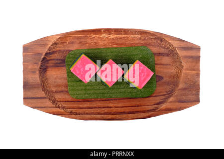 Traditional Malaysian food. Kuih Lapis over the wooden plate isolated on white background. Stock Photo