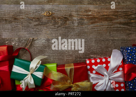 flat lay with presents wrapped in different wrapping papers with ribbons on wooden background Stock Photo