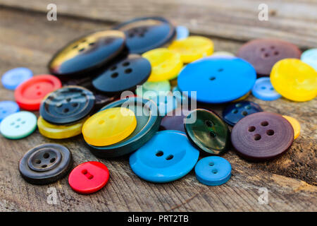 Lots of colorful buttons for clothes on wooden background. Stock Photo
