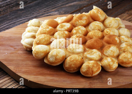 Hong Kong style egg waffle on wooden board. bubble waffle. street food waffles Stock Photo