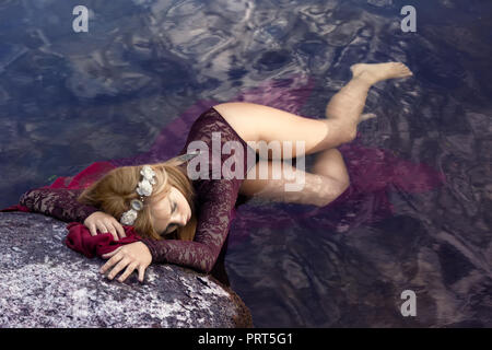 Blonde nymph resting on the lake. Stock Photo