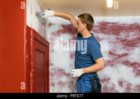 construction worker plastering old apartment walls Stock Photo