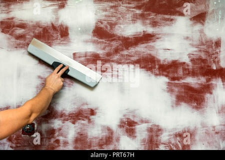 hand with taping knife plastering wall. copy space Stock Photo