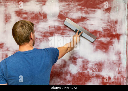 man plastering wall with taping knife Stock Photo