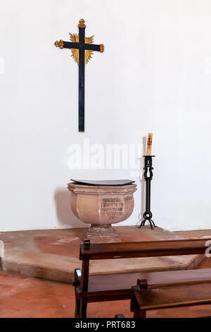 Santarem, Portugal. Gothic Baptismal Font, cross or crucifix and pews in Igreja de Santa Clara Church. 13th century Mendicant Gothic Architecture Stock Photo