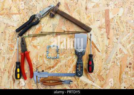Construction tools in the form of house on wooden background. Stock Photo
