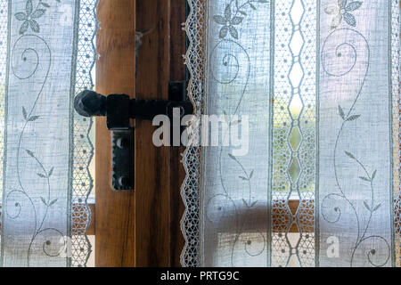 the window behind an embroidered curtain Stock Photo