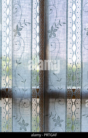 the window behind an embroidered curtain Stock Photo
