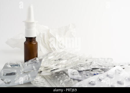 Empty blisters of pills, spray and paper tissue on white background Stock Photo