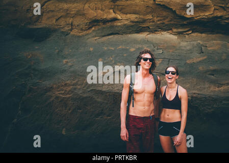 Couple posing against rock face, Canoa, Manabi, Ecuador Stock Photo
