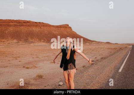 Woman on road in desert, Douba, Morocco Stock Photo
