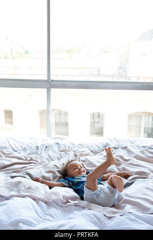 Toddler playing on bed Stock Photo