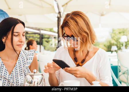 Women having tea on terrace Stock Photo