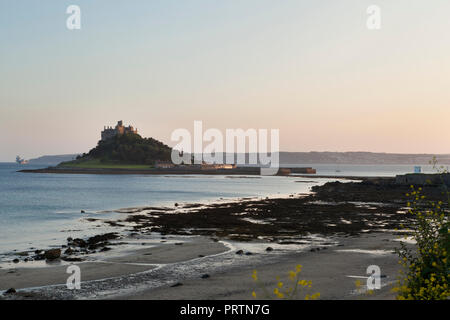 Mount's Bay beach and St. Michael's Mount, with HMS Queen Elizabeth aircraft carrier ship is distance, Cornwall, UK Stock Photo
