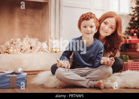 Full length of charming family sitting together Stock Photo