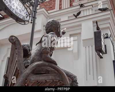 Statue Of A Boy And Girl Sitting On A Bench Reading Book