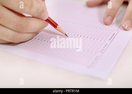 Man is filling OMR sheet with pencil. Stock Photo