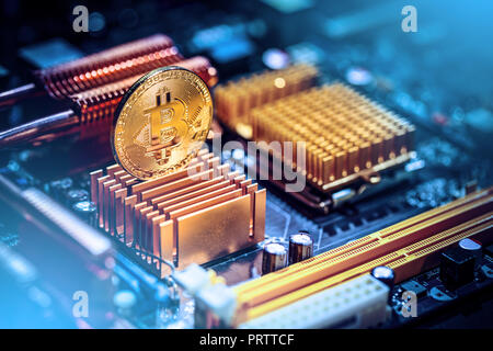 Gold bitcoin coin on a computer motherboard. New independent worldwide cryptocurrency Stock Photo