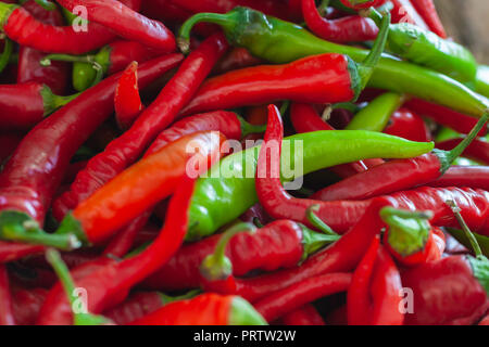 Red and green hot peppers lay on a marketplace counter Stock Photo