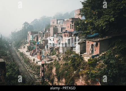 Illustration of the life of the poor in the Indian ghetto. Houses on a slope near a dirty dump. Stock Photo