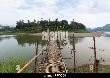 Wooden bamboo bridge over Nam Khan River at low tide viewed from the front in Luang Prabang, Laos.
