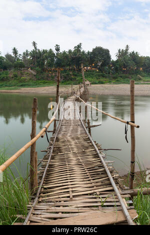 Wooden bamboo bridge over Nam Khan River at low tide viewed from the front in Luang Prabang, Laos. Stock Photo