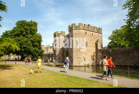 Visitors and tourists around  the moat to the Bishop's Palace in the grounds of Wells cathedral Somerset England UK Stock Photo