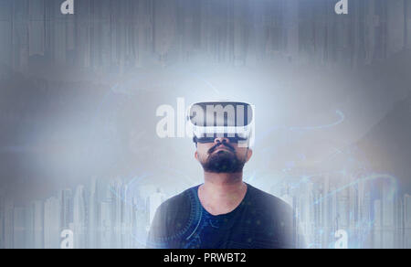 Young Guy in black t shirt looking through VR (Virtual Reality) glasses - Looking Up Stock Photo