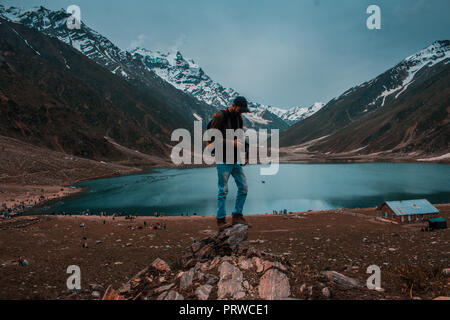 Traveller stand on a rock at Lake Saif Al Maluk in Naran Valley, Pakistan Stock Photo