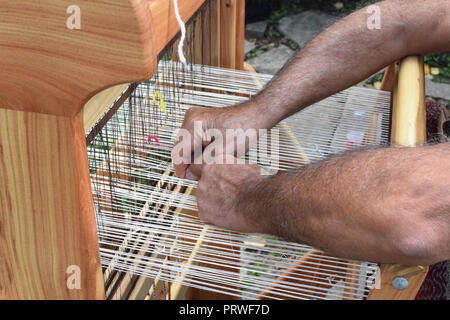 Hands of middle-aged man - craftsman weaver - working on wooden handloom, Etara ethnographic reserve, Bulgaria Stock Photo