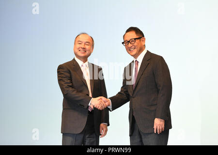 Tokyo. 4th, 2018. Masayoshi Son (L), Chairman and CEO of SoftBank, shakes hands with Toyota Motor Corp. President Akio Toyoda during a press conference in Tokyo, Japan, Oct. 4, 2018. Toyota Motor Corp. and SoftBank Group Corp. on Thursday announced they will set up a joint venture developing self-driving cars and ride-sharing services, with the new mobility firm to be launched next year. Credit: Hua Yi)(yk/Xinhua/Alamy Live News Stock Photo