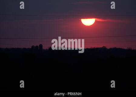 Sunset peeking from the bottom of the clouds. Stock Photo