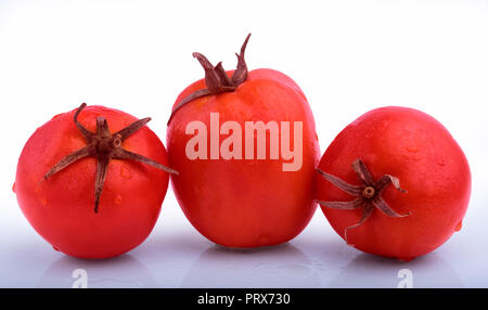 Three Tomato with water drops on it  Isolated on a white background. at   mumbai Maharashtra india Stock Photo