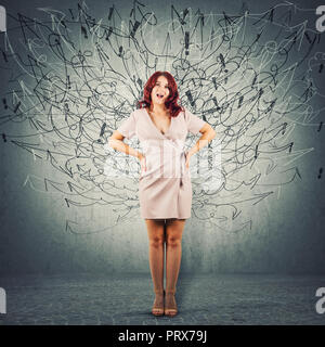 Full length portrait of a young angry woman standing with hands on hips screaming, mouth opened like scolding someone. Hundreds of arrows and curves m Stock Photo