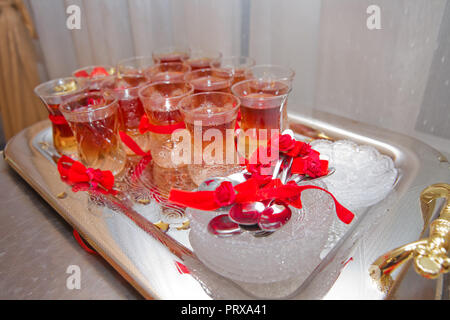 tea in eastern glass on the silver salver on the white tablecloth, Arabic, Turkish, Azerbaijani customs Stock Photo