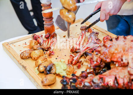 Barbecue is prepared of lamb or sheep meat and processed by slasher. Roasted meat over an open fire, cooked in a special way. Stock Photo