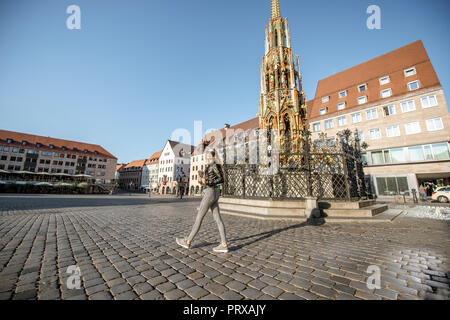 Young woman tourist near the beautiful fountain on the market square traveling in Nurnberg, Germany Stock Photo