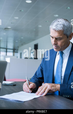 Businessman signing document Stock Photo