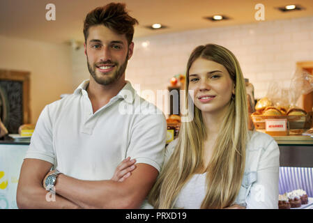 Couple standing in cake shop Stock Photo