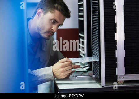 Engineer inserting chip into machine Stock Photo