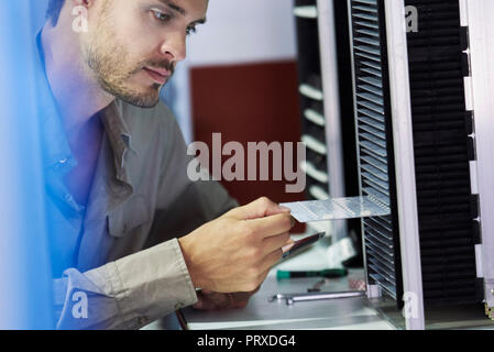 Close-up of engineer inserting chip into machine Stock Photo
