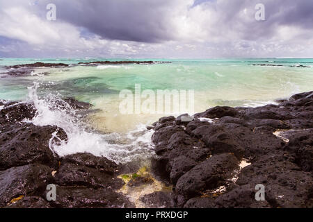 waves crushing at Lava rocks on beach of the tropical volcaninc island of Mauritius Stock Photo