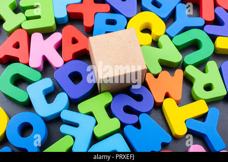 Cardboard box cube and Colorful Letters of Alphabet Stock Photo